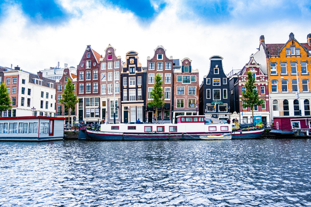 Old colorful houses by the river in Amsterdam