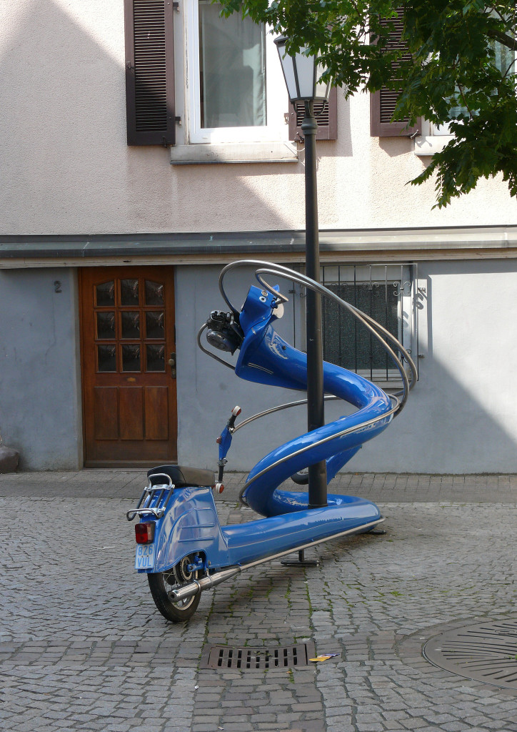 Blue Vespa artfully twisted around a lamp post