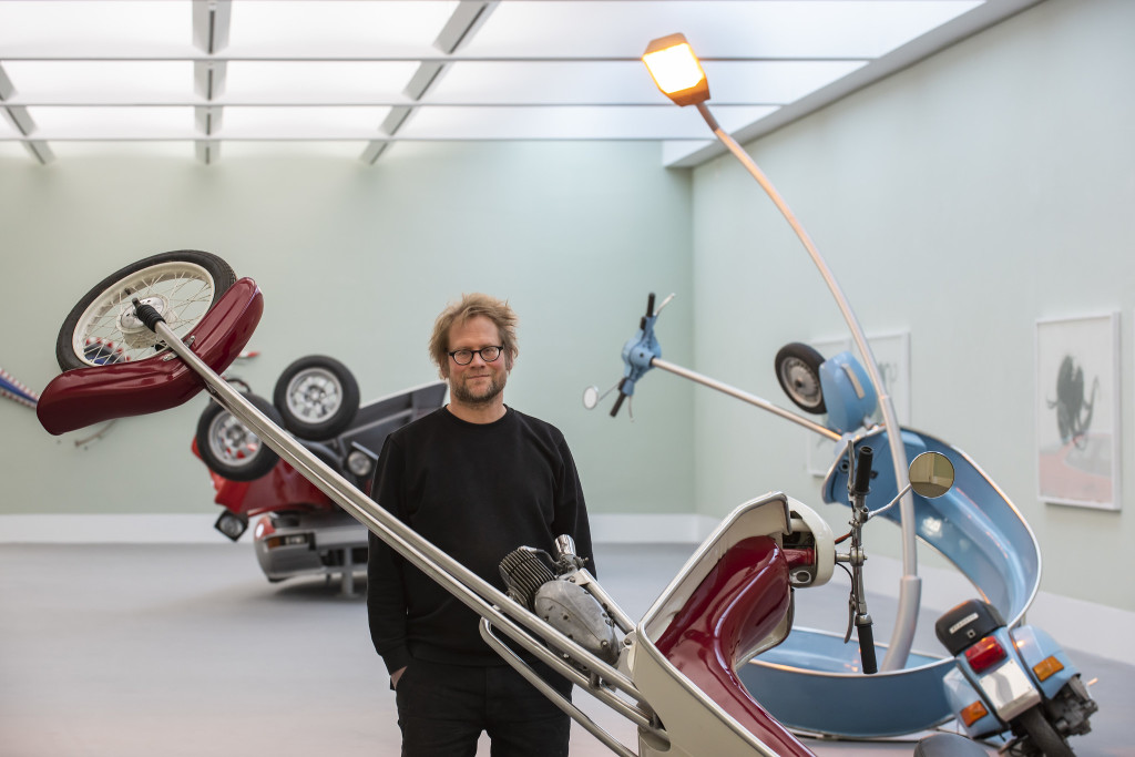Stefan Rohrer stands among his artworks in a gallery