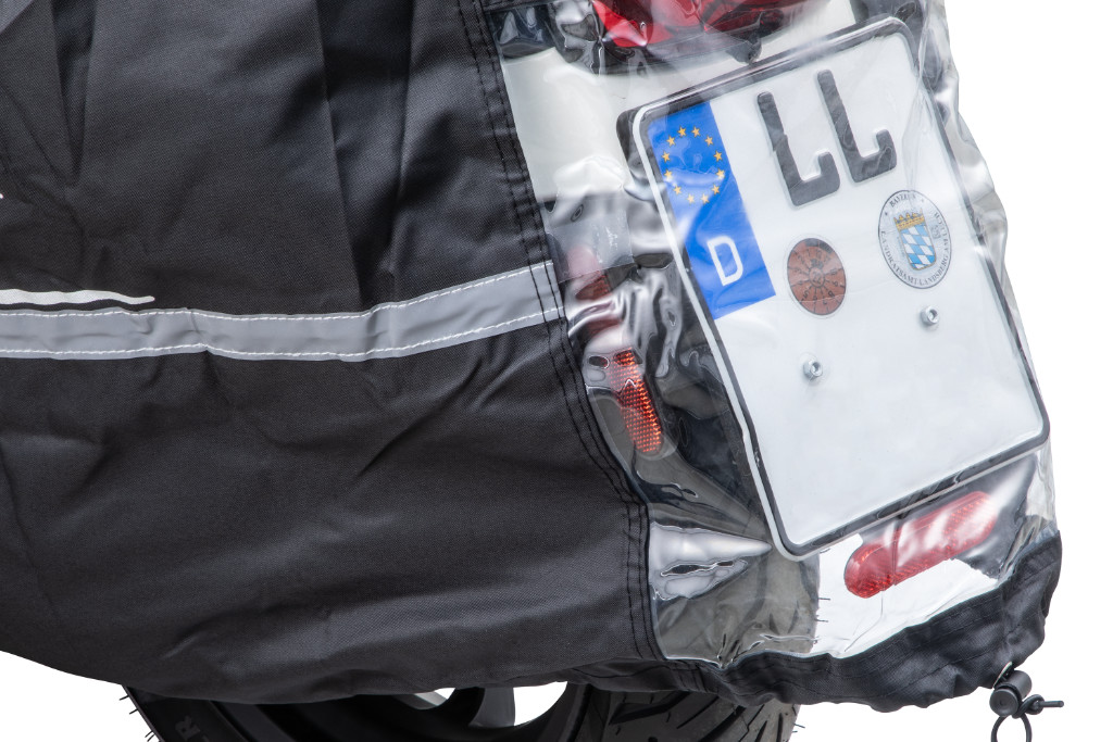 Number plate of a Vespa visible through the window of a folding garage.