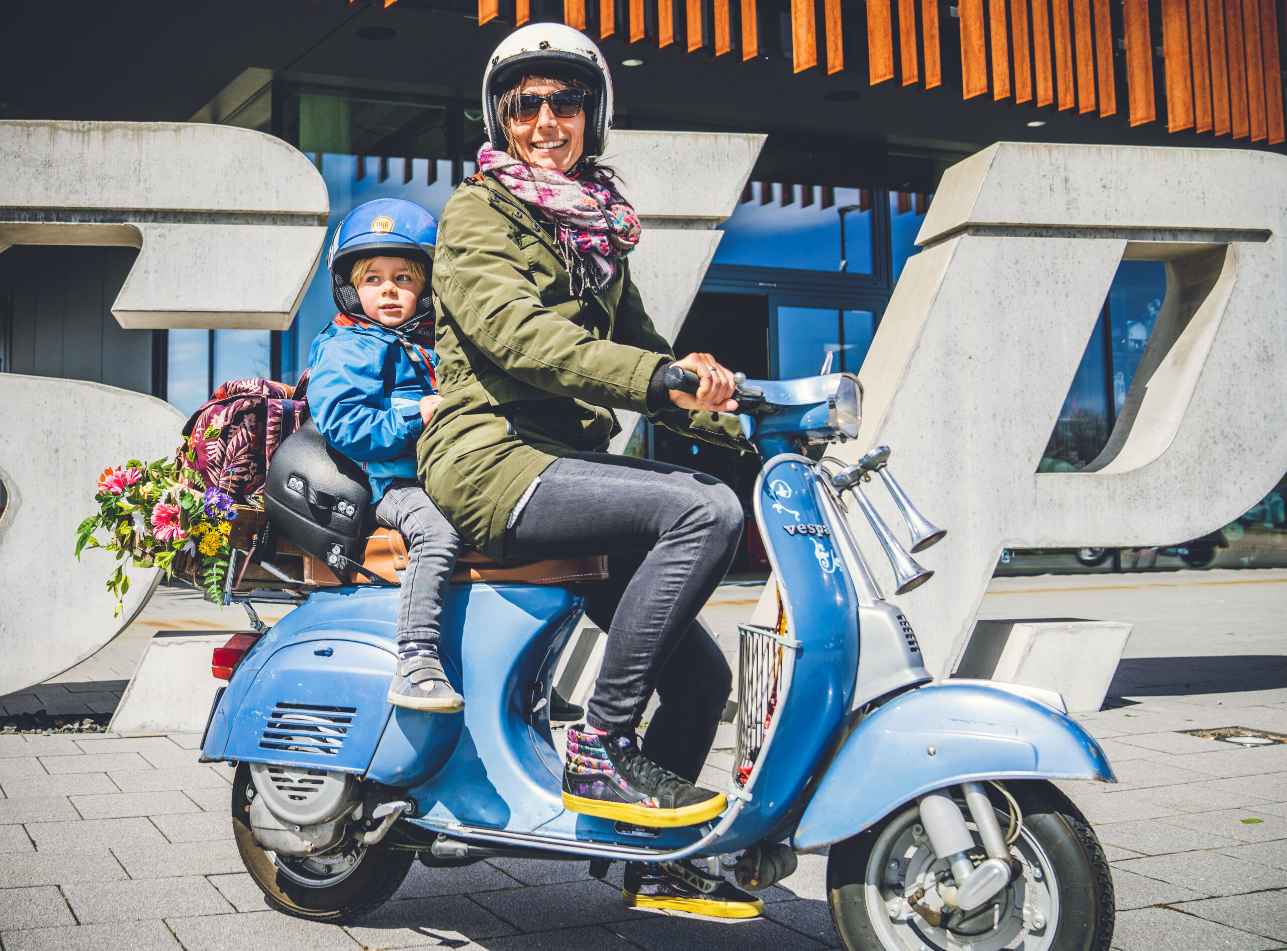 Child on a vespa with its mother