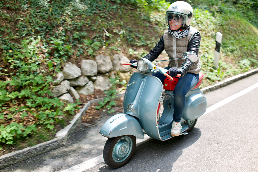 Woman driving a blue Vespa