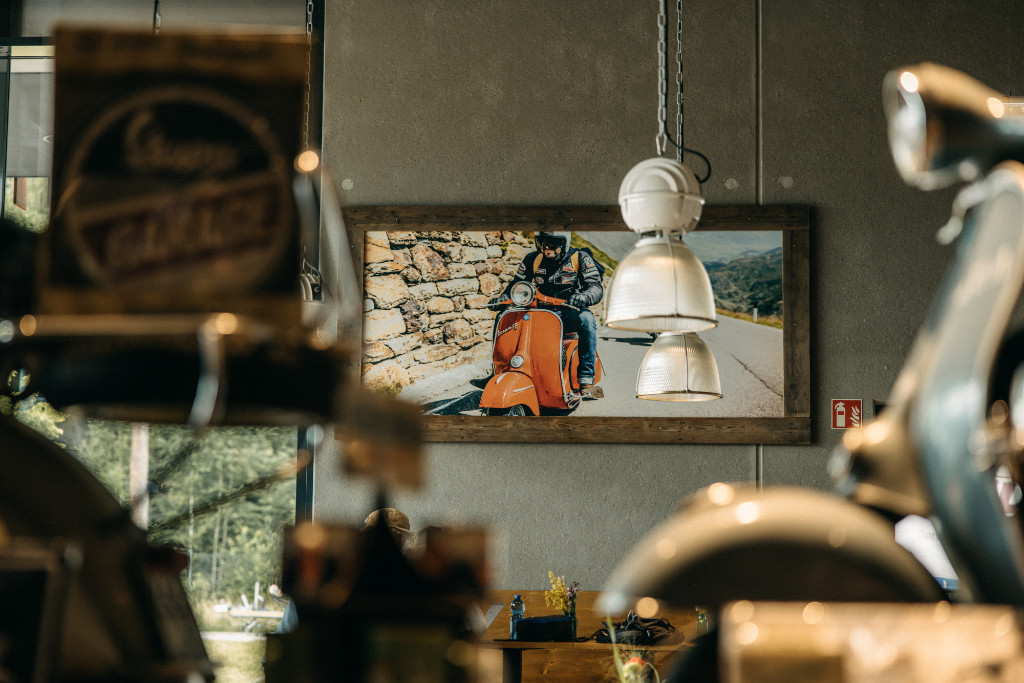 Hanging lamp and picture of a Vespa on the wall, blurred foreground

