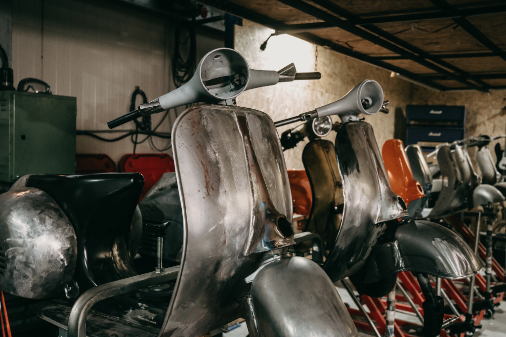 Old Vespa chassis lined up in a workshop.
