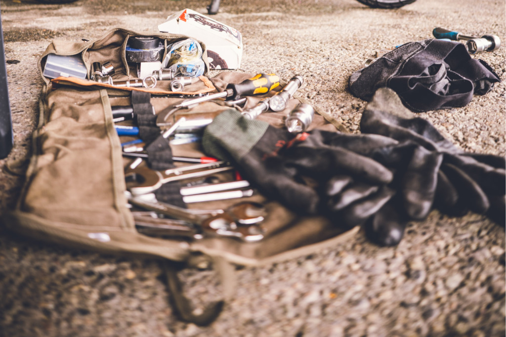 Werkzeugtasche liegt auf dem Boden mit schwarzen Handschuhen daneben